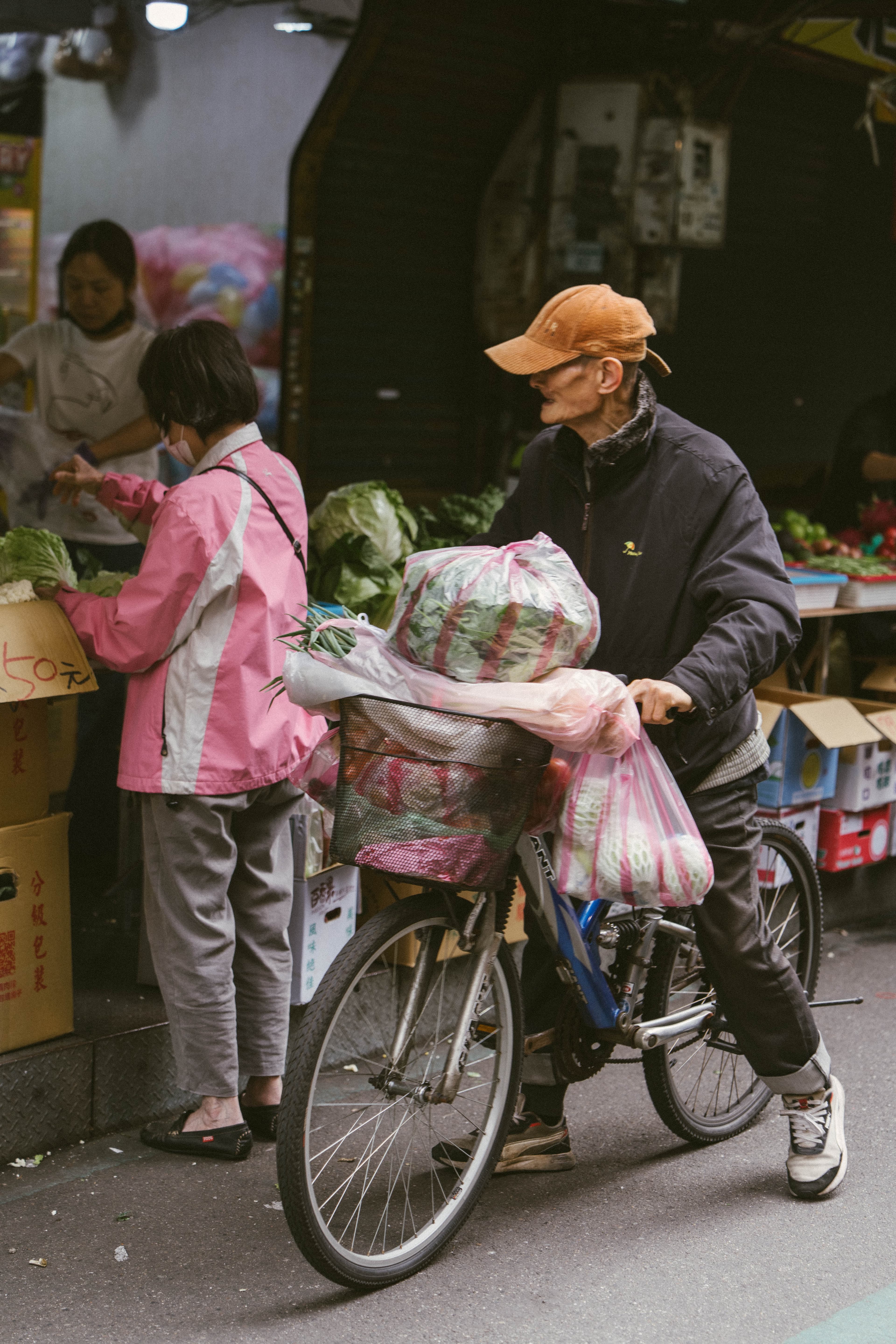 man on bicycle with produce in basket